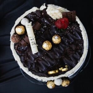 Overhead view of a rich chocolate cake topped with strawberries, white chocolate, and Ferrero Rocher in Sydney.