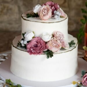 A beautiful wedding cake with floral decorations beside champagne in Lisboa, Portugal.